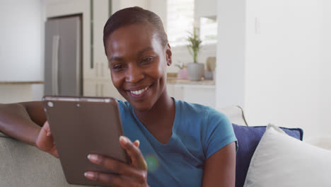 Glückliche-Afroamerikanische-Frau-Sitzt-Auf-Dem-Sofa-Und-Benutzt-Ein-Digitales-Tablet