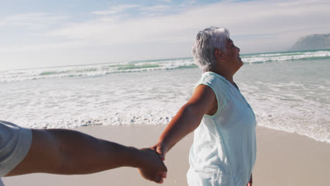 Älteres-Afroamerikanisches-Paar-Geht-Spazieren-Und-Hält-Händchen-Am-Strand