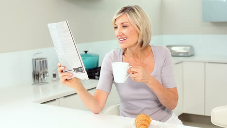 Blonde-Frau-Liest-Zeitung-Und-Trinkt-Kaffee