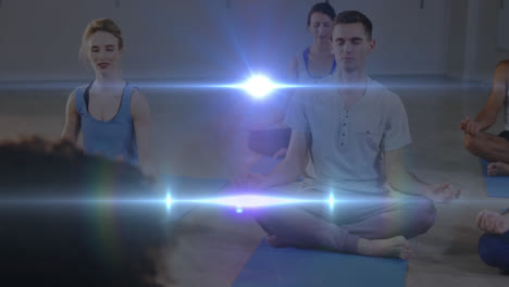 Animation-of-glowing-light-over-people-practicing-yoga