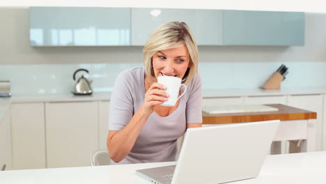 Blonde-Frau-Trinkt-Kaffee,-Während-Sie-Ihren-Laptop-Benutzt