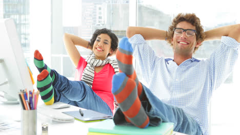 Two-colleagues-reclining-on-their-swivel-chair-