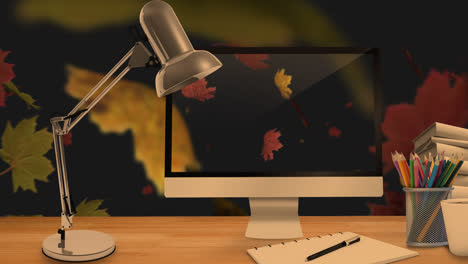 Desktop-Computer-Und-Bürogeräte-Auf-Einem-Tisch-Vor-Herbstlichen-Ahornblättern,-Die-Im-Hintergrund-Schweben