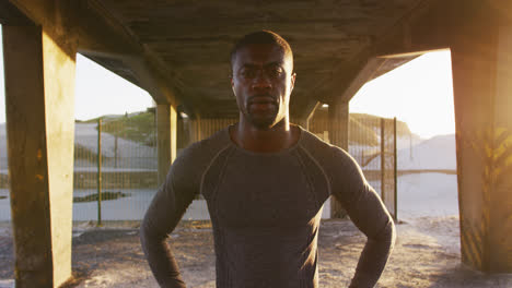 Porträt-Eines-Fokussierten-Afroamerikanischen-Mannes,-Der-In-Die-Kamera-Blickt-Und-Abends-Im-Freien-Trainiert