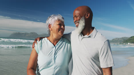 Smiling-senior-african-american-couple-embracing-at-the-beach