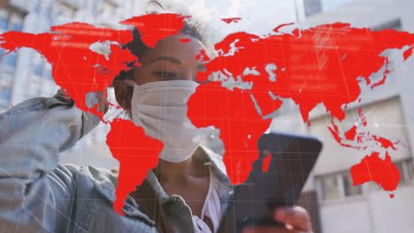 Animation-of-world-map-showing-infection-over-woman-in-face-mask-using-smartphone-in-city