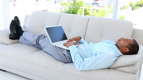 Businessman-falling-asleep-on-the-sofa-with-laptop