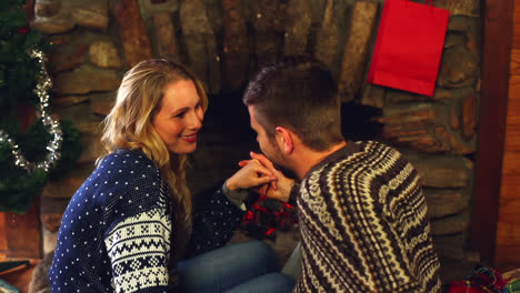 Cute-couple-celebrating-christmas-together-in-front-the-fire