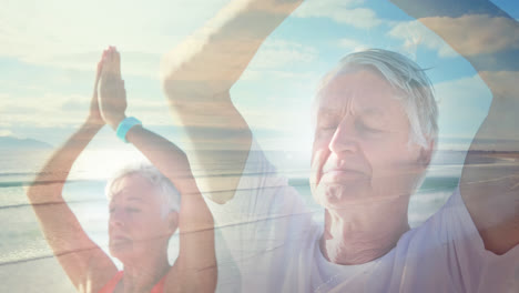 Animation-of-glowing-light-over-senior-couple-practicing-yoga-by-seaside