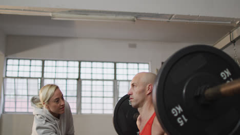 Kaukasischen-Muskulösen-Mann-Gewichtheben-Mit-Weiblichen-Trainer