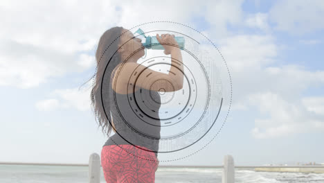Animation-of-scope-scanning-over-woman-with-artificial-limb-drinking-water-by-seaside