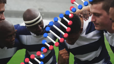 Animation-of-dna-strand-over-male-rugby-players-at-stadium