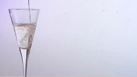 Animation-Von-Schnee,-Der-über-Ein-Champagnerglas-Auf-Weißem-Hintergrund-Fällt
