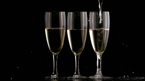 Animation-of-burning-document-over-champagne-pouring-into-three-glasses-on-black-background
