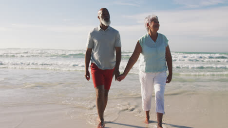 Älteres-Afroamerikanisches-Paar-Geht-Spazieren-Und-Hält-Händchen-Am-Strand