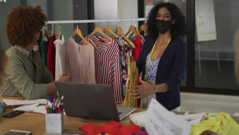Mixed-race-clothes-designers-having-video-call-wearing-face-masks