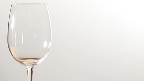 Animation-of-burning-paper-over-glass-of-wine-on-white-background