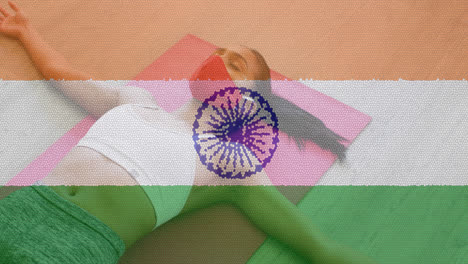 Animation-of-woman-wearing-face-mask-practicing-yoga-over-indian-flag