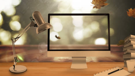 Desktop-computer-and-office-equipment-on-a-table-against-autumn-maples-leaves-falling-in-background