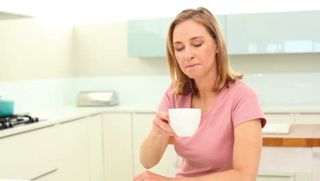 Mature-woman-drinking-coffee-and-reading-newspaper