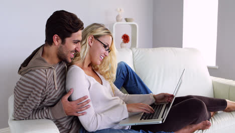 Glückliches-Paar,-Das-Auf-Der-Couch-Sitzt-Und-Den-Laptop-Benutzt