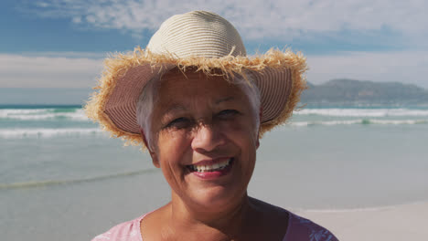 Portrait-of-mixe-race-senior-woman-smiling-at-the-beach