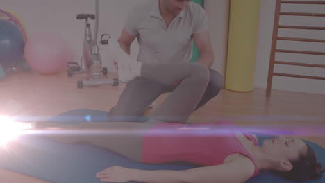 Animation-of-glowing-light-over-woman-exercising-with-fitness-instructor