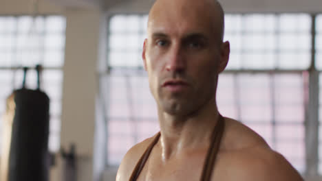 Portrait-of-fit-caucasian-man-with-jump-ropes-around-his-neck-at-the-gym