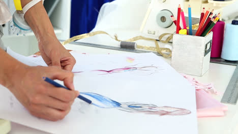 Fashion-designer-sketching-a-blue-dress-design