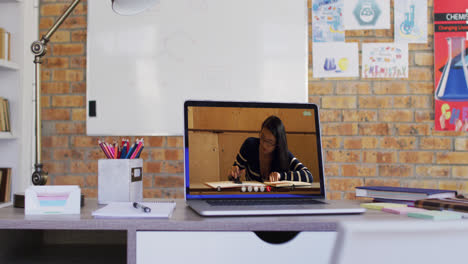 Mixed-race-female-student-learning-displayed-on-laptop-screen-during-video-call