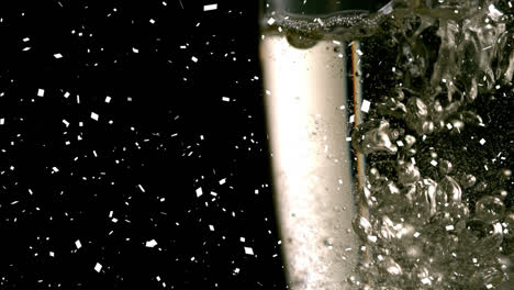 Animation-of-white-confetti-falling-over-champagne-pouring-into-three-glasses-on-black-background