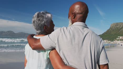 Senior-african-american-couple-embracing-at-the-beach