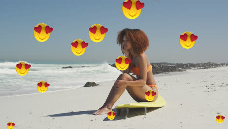 Animation-Von-Digitalen-Symbolen-Mit-Roten-Herz-Liebes-Emojis-über-Einer-Lächelnden-Frau,-Die-Auf-Einem-Surfbrett-Am-Strand-Sitzt