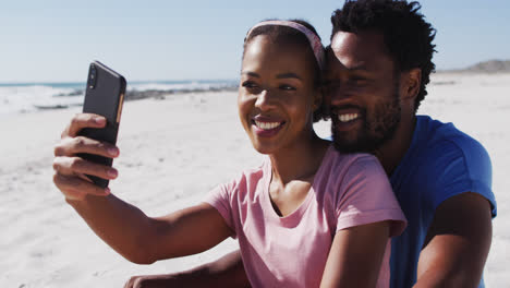 Pareja-Afroamericana-Sonriendo-Tomando-Selfie-Con-Teléfono-Inteligente-En-La-Playa