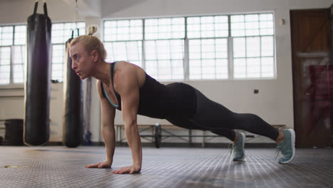 Fit-caucasian-woman-performing-push-up-exercise-at-the-gym