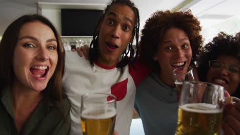 Eine-Bunt-Gemischte-Gruppe-Glücklicher-Freunde-Schaut-Sich-Ein-Spiel-An,-Trinkt-Bier-Und-Macht-Ein-Selfie-In-Einer-Bar