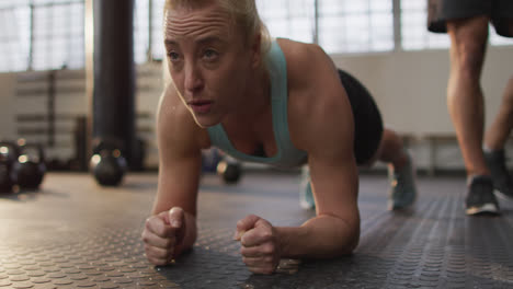 Close-up-of-fit-caucasian-woman-performing-plank-exercise-at-the-gym