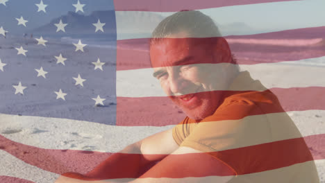 Animation-of-american-flag-waving-over-senior-man-smiling-on-beach