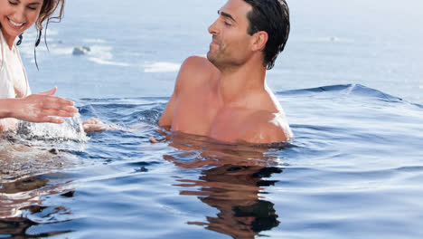 Smiling-caucasian-couple-on-holiday-splashing-in-sea