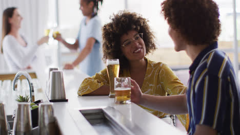 Grupo-Diverso-De-Amigos-Felices-Bebiendo-Cervezas-Y-Hablando-En-Un-Bar