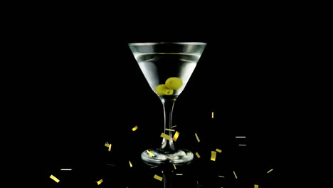 Animation-of-gold-confetti-falling-over-glass-of-wine-with-olives-on-black-background