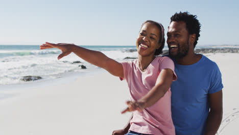 African-american-couple-smiling-and-embracing-on-the-beach