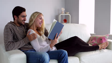 Cute-young-couple-reading-together-on-the-couch-