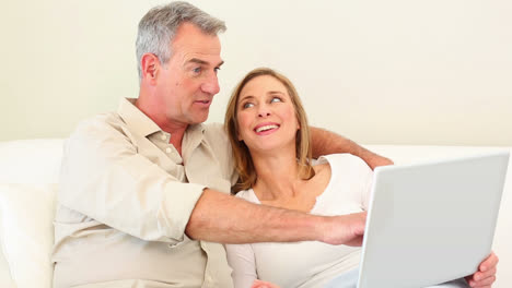 Mature-couple-using-laptop-together-on-the-couch