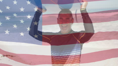 Animation-of-american-flag-waving-over-senior-man-carrying-surfboard-on-head-on-beach