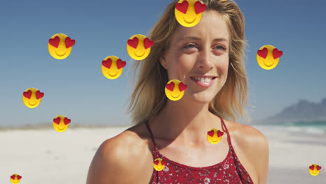 Animation-Von-Digitalen-Symbolen-Mit-Roten-Herz-Liebes-Emojis-über-Einer-Lächelnden-Frau-Am-Strand