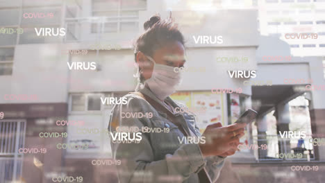Animation-of-text-virus-and-covid-19-repeated-over-woman-in-face-mask-using-smartphone-in-street