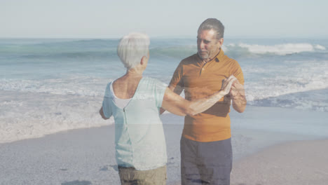 Animation-of-glowing-light-over-portrait-of-happy-senior-couple-dancing-by-seaside