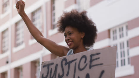 Mujer-Afroamericana-Sosteniendo-Un-Cartel-Gritando-Levantando-El-Puño-Durante-La-Protesta