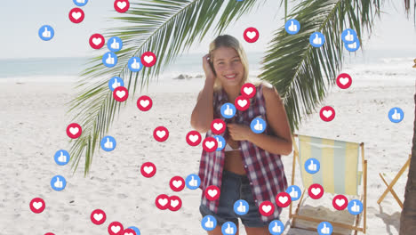 Animation-of-red-heart-love-and-like-digital-icons-over-smiling-woman-on-beach